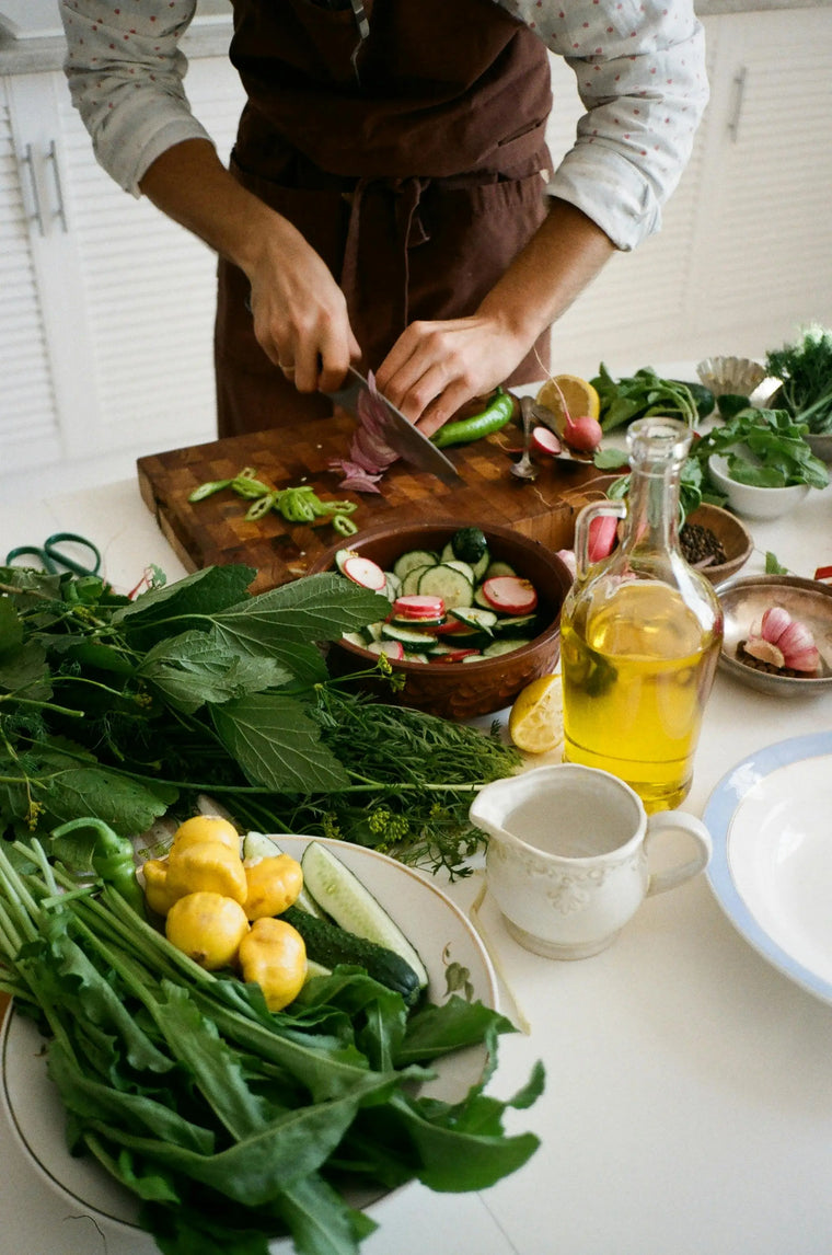 Homme dans une cuisien découpe des légumes